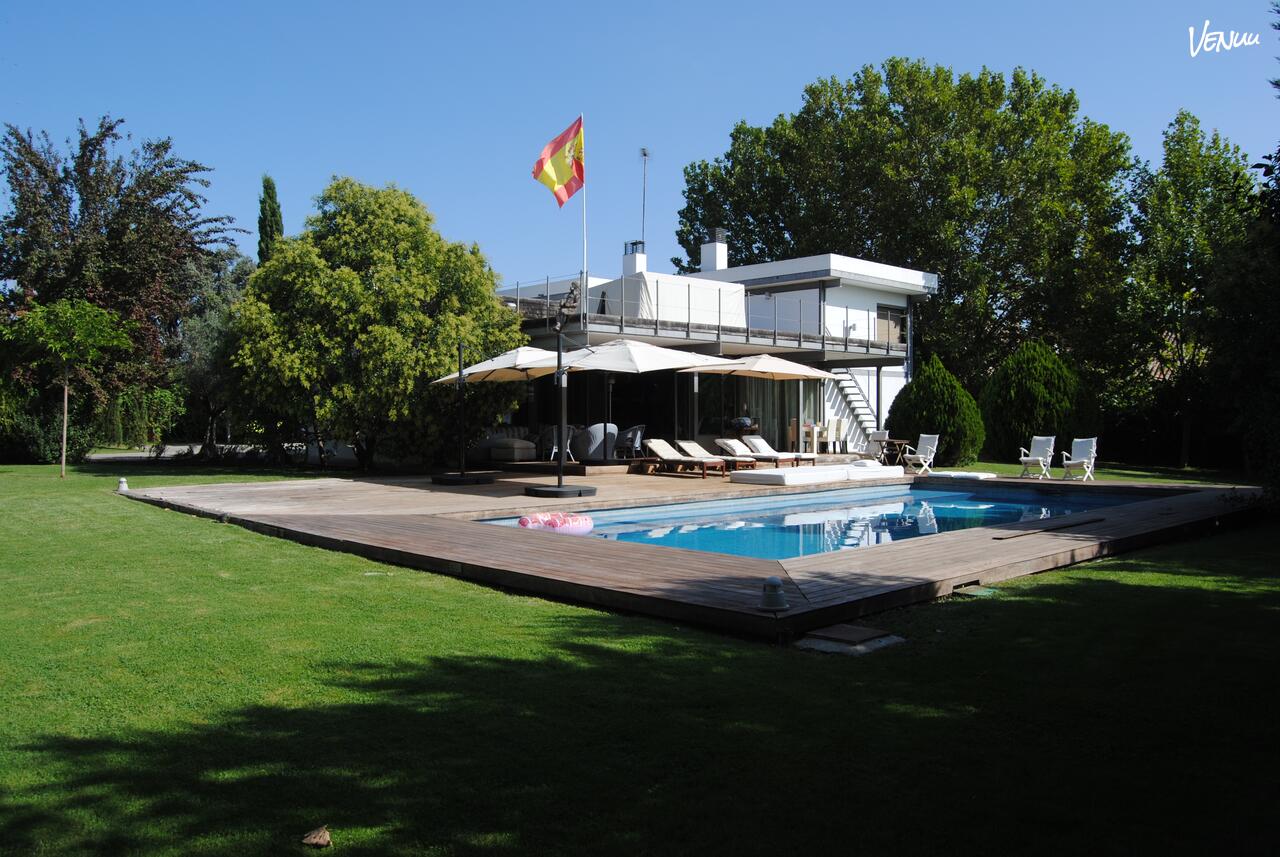 Jardín con piscina y zona de barbacoa en Casa Fuente, ideal para fiestas de empresa en Madrid.